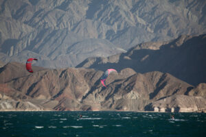 Kitesurfing nearer the dam wall on Cuesta del Viento - two kite-surfers crossing paths in the distance Kitesurfing nearer the dam wall on Cuesta del Viento - two kite-surfers crossing paths in the distance