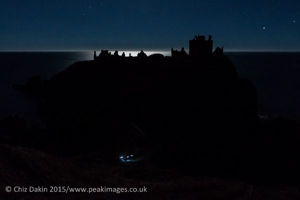 Ghost hunters exploring Dunottar Castle by torch and moonlight.